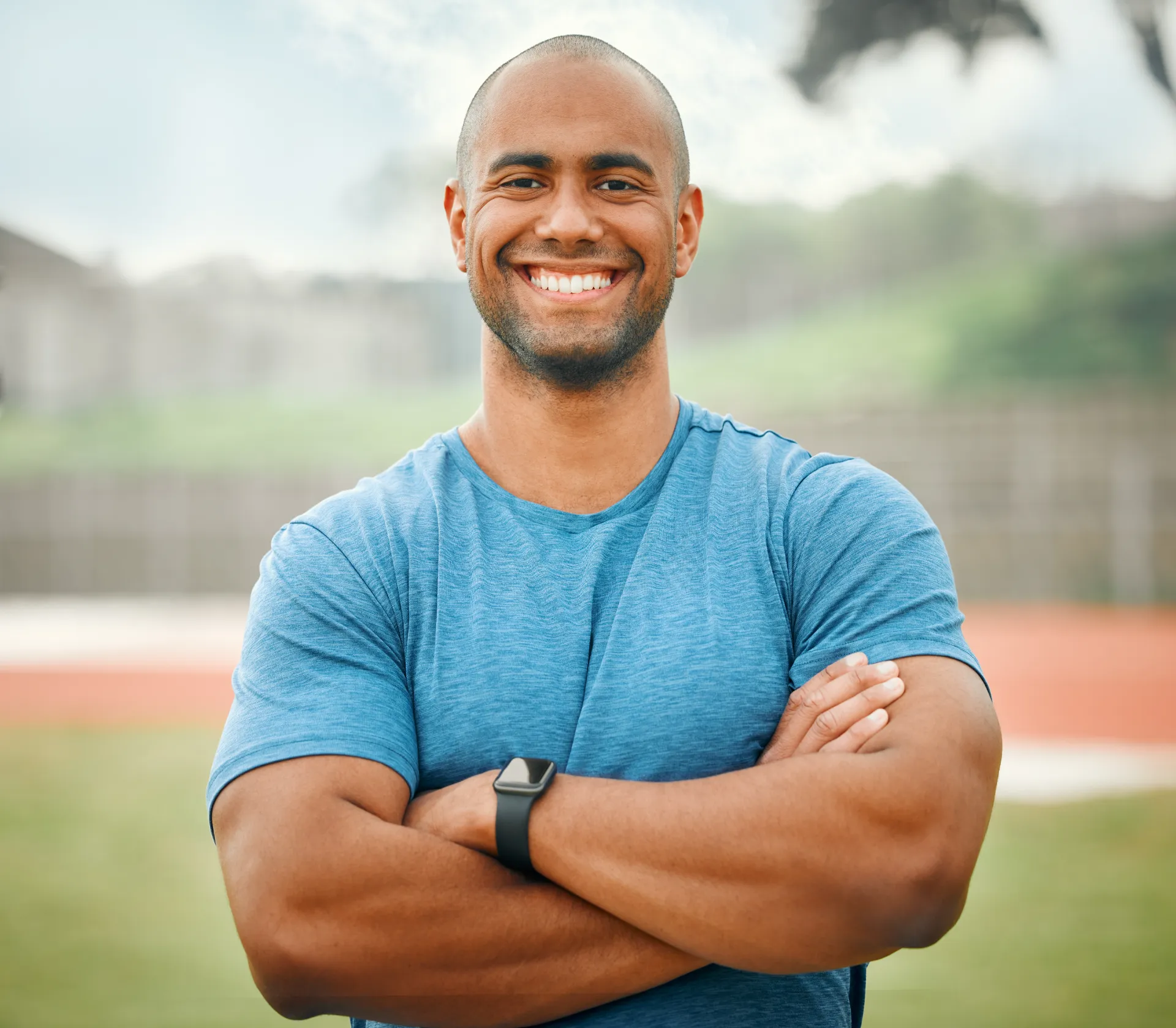 smiling man in blue shirt standing outdoors utc